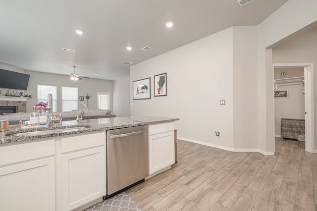 kitchen featuring dishwasher, light wood-style floors, open floor plan, and a sink