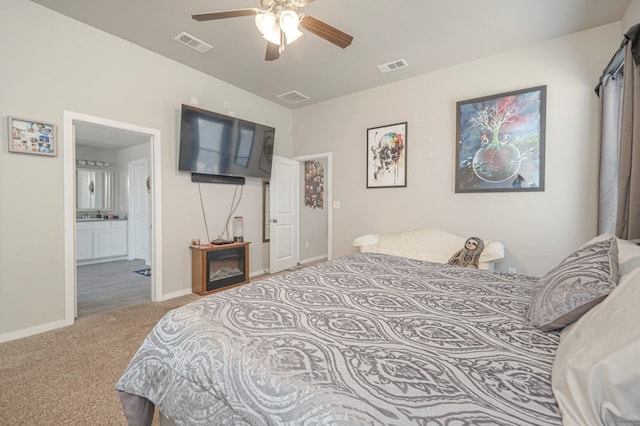 carpeted bedroom featuring baseboards, visible vents, and ensuite bathroom