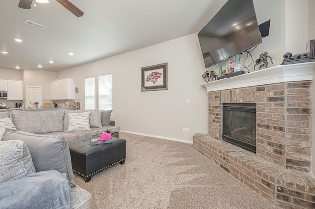 living room featuring visible vents, recessed lighting, a fireplace, baseboards, and light colored carpet