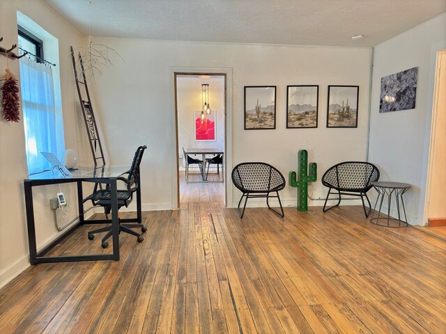 home office with hardwood / wood-style floors and a textured ceiling