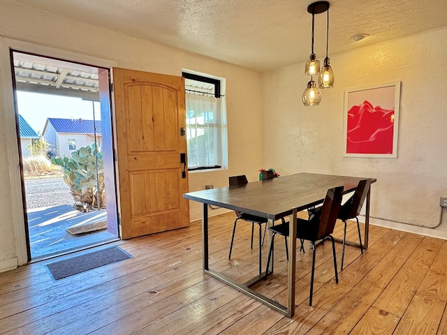 dining room featuring a textured ceiling and light wood-type flooring