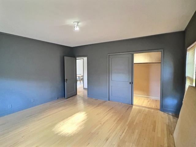 unfurnished bedroom with light hardwood / wood-style floors and a closet