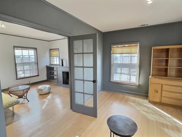 doorway featuring a fireplace, a healthy amount of sunlight, and light wood-type flooring