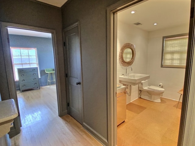 bathroom with toilet, wood-type flooring, and sink