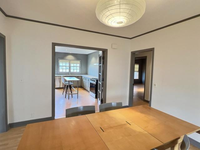 unfurnished dining area with light hardwood / wood-style floors and ornamental molding