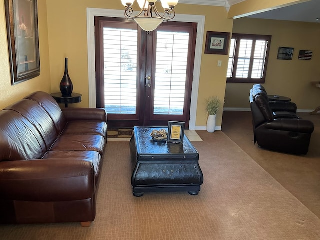 carpeted living room with french doors, baseboards, a notable chandelier, and ornamental molding