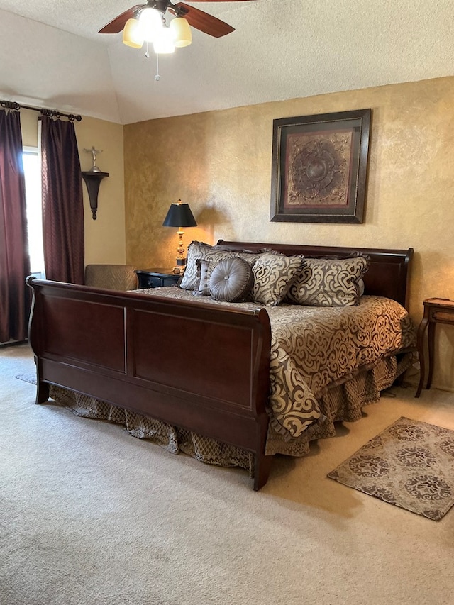 bedroom with a ceiling fan, carpet, vaulted ceiling, a textured ceiling, and a textured wall