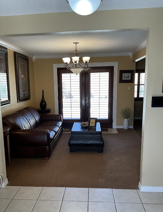 living room with a textured ceiling, an inviting chandelier, light tile patterned flooring, and ornamental molding