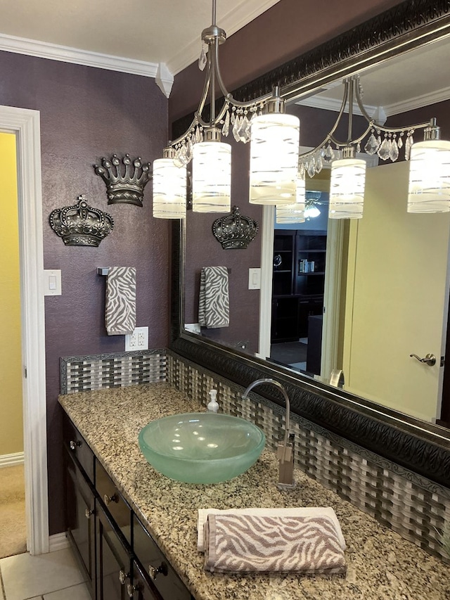 bathroom featuring tile patterned floors, vanity, crown molding, and baseboards