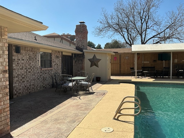 view of swimming pool featuring outdoor dining space, a fenced in pool, a patio, and fence