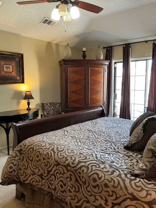 bedroom with visible vents, carpet floors, a textured ceiling, and ceiling fan