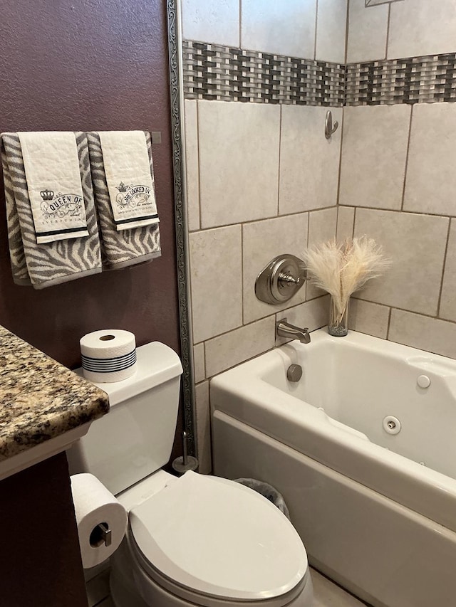 bathroom featuring toilet, a textured wall, and a combined bath / shower with jetted tub