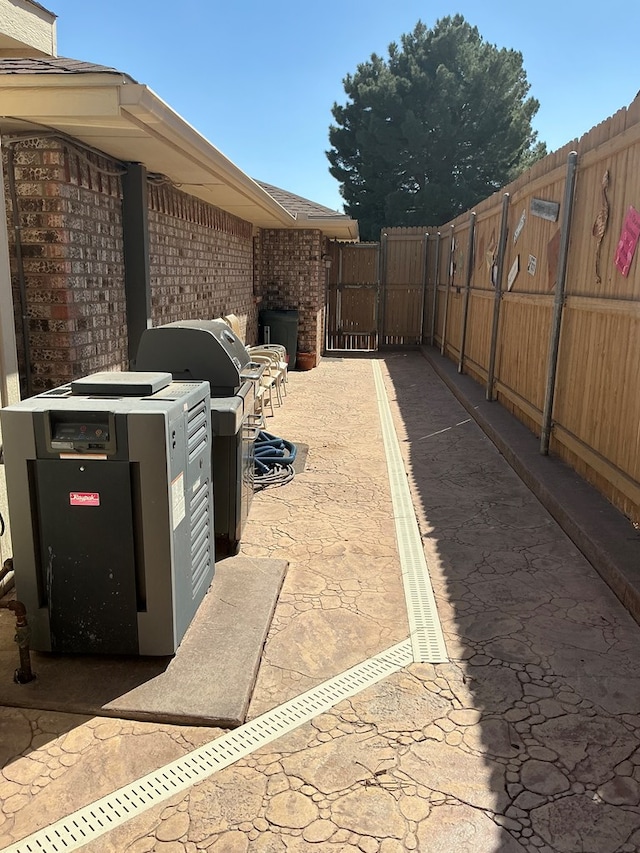 view of patio with area for grilling and fence