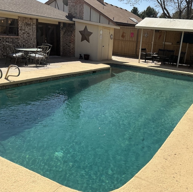 view of swimming pool featuring a patio, fence, a fenced in pool, and french doors