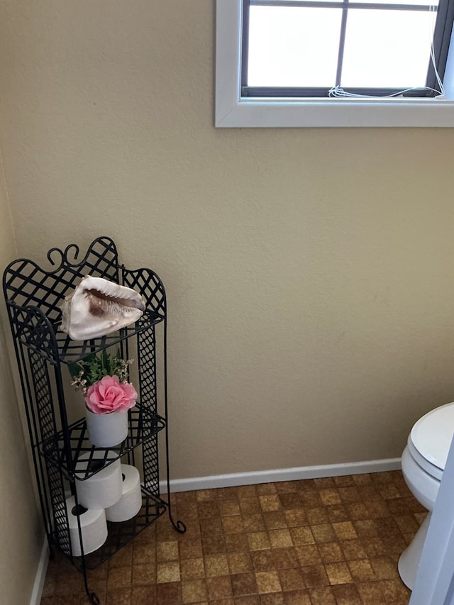 bathroom featuring toilet and baseboards