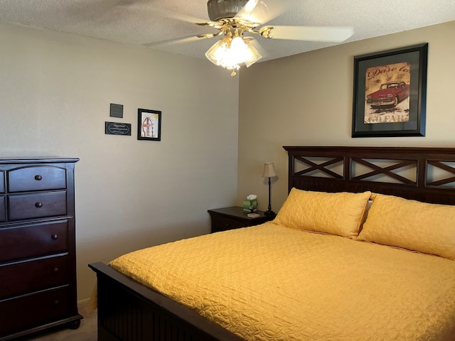 bedroom with ceiling fan and a textured ceiling