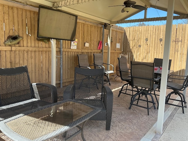 view of patio / terrace featuring outdoor dining space, a ceiling fan, and fence