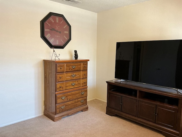 bedroom with a textured ceiling, visible vents, baseboards, and light carpet