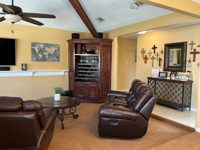 living room with visible vents, a ceiling fan, carpet flooring, tile patterned flooring, and vaulted ceiling with beams