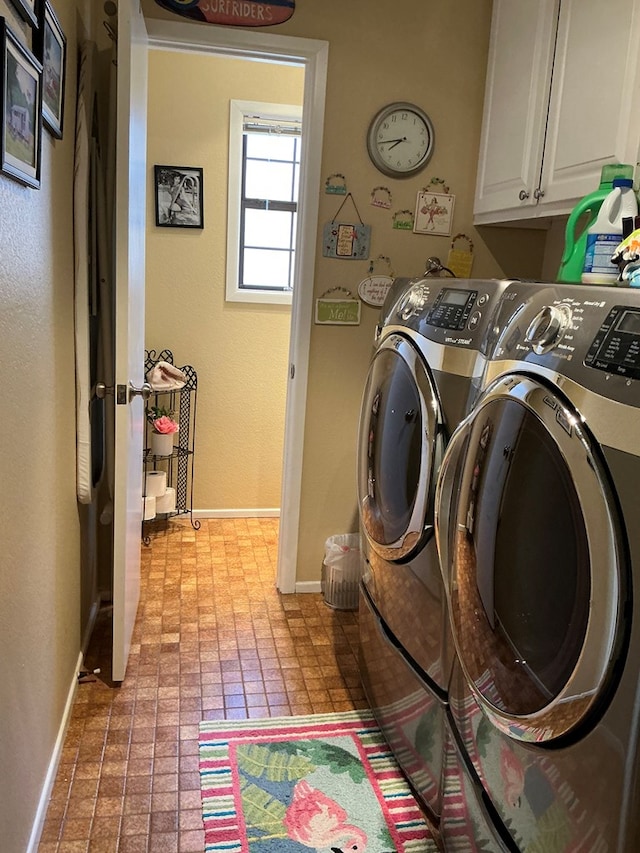 laundry area with separate washer and dryer, brick floor, cabinet space, and baseboards