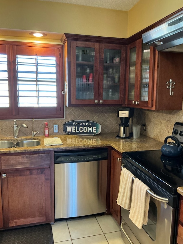 kitchen with ventilation hood, stainless steel appliances, tasteful backsplash, and a sink