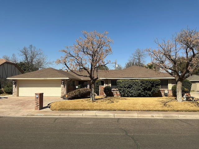 single story home with brick siding, concrete driveway, and a garage