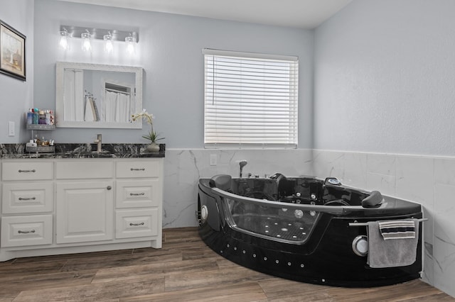 bathroom with hardwood / wood-style flooring, vanity, and tile walls