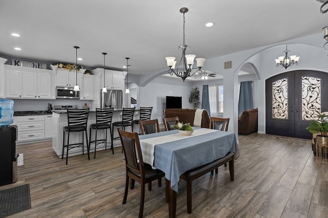 dining space with a notable chandelier, dark wood-type flooring, and french doors