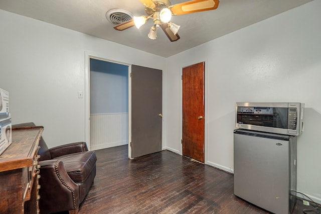 office with dark hardwood / wood-style flooring and ceiling fan