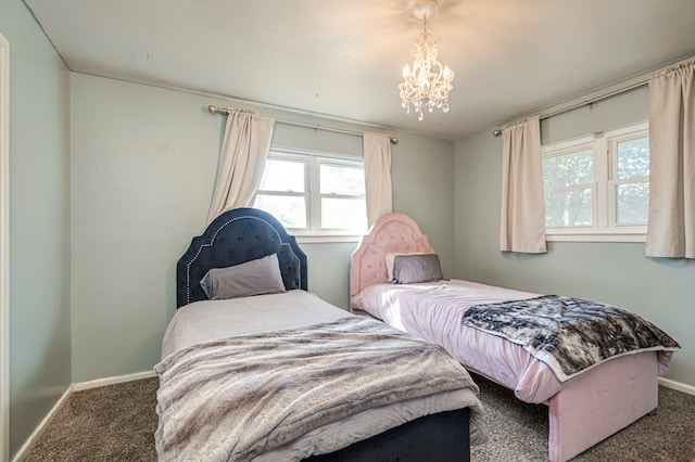 carpeted bedroom featuring multiple windows and a notable chandelier