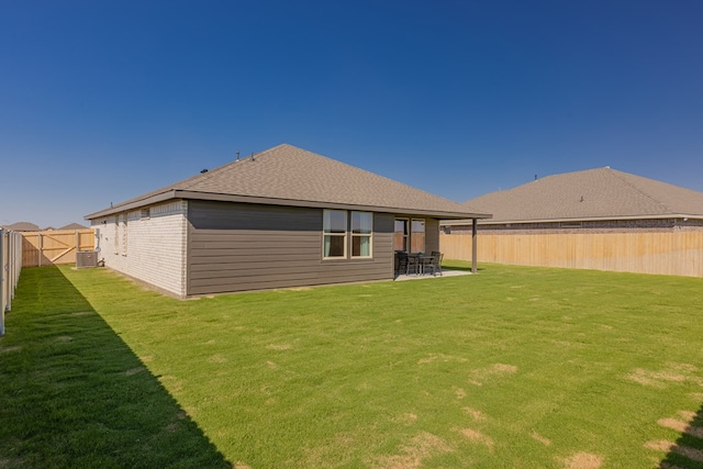 rear view of house with a lawn, central AC unit, and a patio area