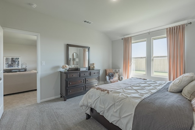 bedroom with light colored carpet and vaulted ceiling