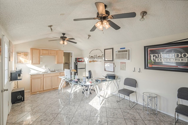 interior space with vaulted ceiling, a wall mounted air conditioner, light brown cabinetry, sink, and a textured ceiling