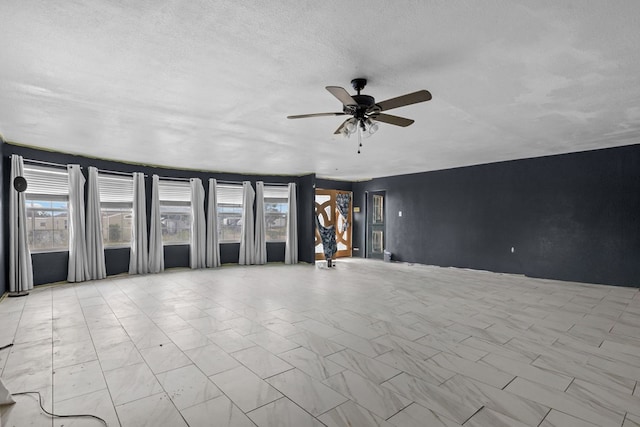 8528 W 24th St, Odessa, TX 79763 - unfurnished living room featuring ceiling fan, marble finish floors, and a textured ceiling