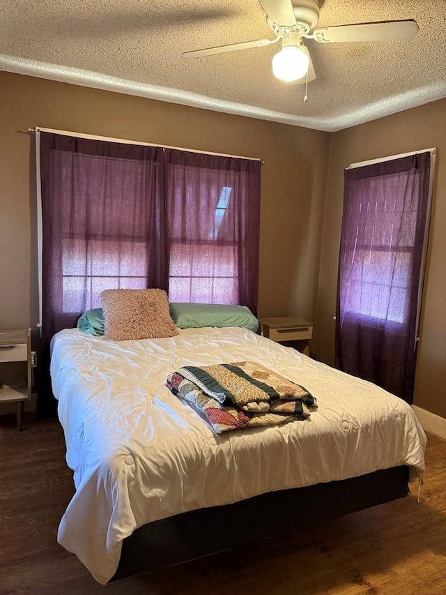 711 24th St, Crane, TX 79731 - bedroom featuring multiple windows, wood finished floors, a textured ceiling, and ceiling fan