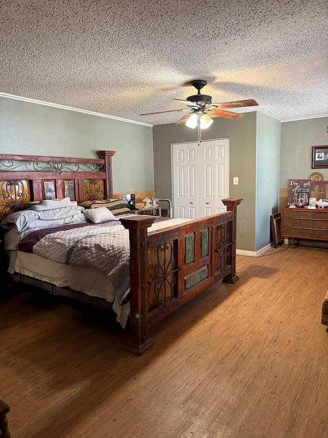 711 24th St, Crane, TX 79731 - bedroom with wood finished floors, a textured ceiling, a ceiling fan, and a closet