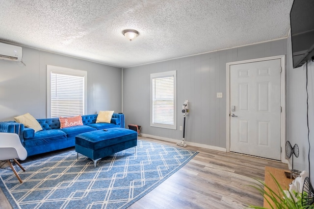 2707 Eisenhower Rd, Odessa, TX 79762 - living area featuring wood finished floors, a wall unit AC, and a textured ceiling