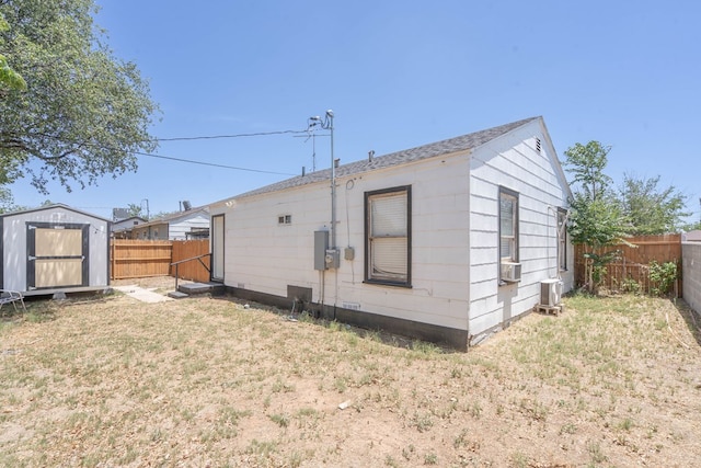2707 Eisenhower Rd, Odessa, TX 79762 - rear view of property with a fenced backyard, cooling unit, and a storage unit