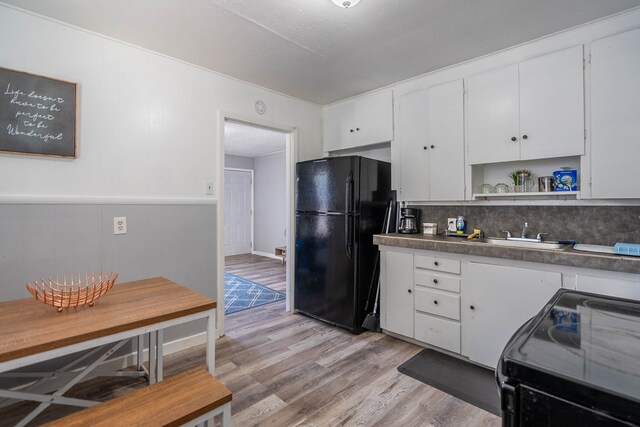 2707 Eisenhower Rd, Odessa, TX 79762 - kitchen with black appliances, open shelves, light wood-style floors, white cabinetry, and backsplash