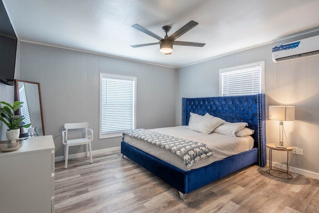 2707 Eisenhower Rd, Odessa, TX 79762 - bedroom featuring wood finished floors, a wall mounted air conditioner, and a ceiling fan