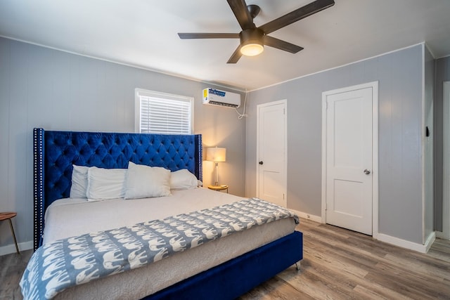 2707 Eisenhower Rd, Odessa, TX 79762 - bedroom with a wall unit AC, wood finished floors, and a ceiling fan