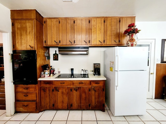 2104 Redbud Ave, Odessa, TX 79761 - kitchen with black appliances, under cabinet range hood, brown cabinetry, light countertops, and light tile patterned floors