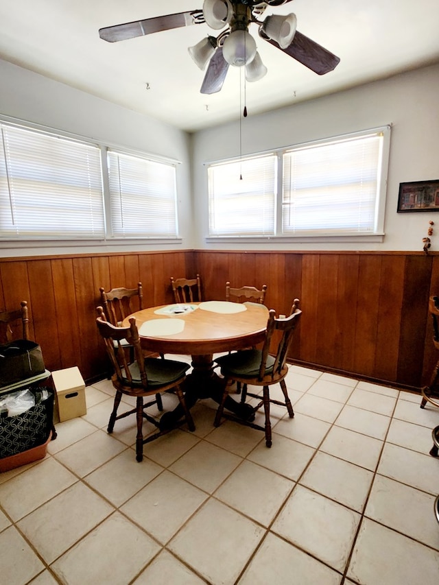 2104 Redbud Ave, Odessa, TX 79761 - dining area featuring wainscoting, wood walls, a ceiling fan, and light tile patterned floors