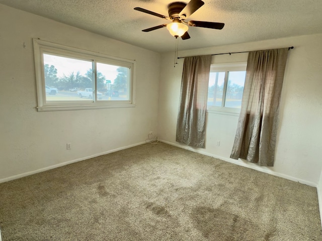 empty room with baseboards, carpet flooring, a textured ceiling, and ceiling fan