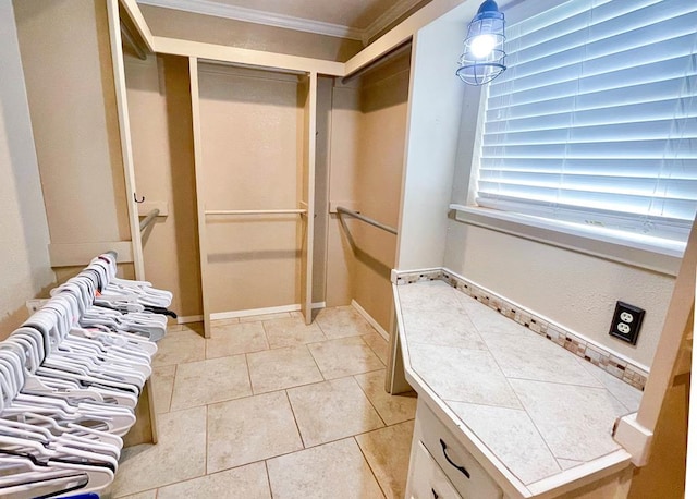 bathroom featuring tile patterned floors, crown molding, and baseboards