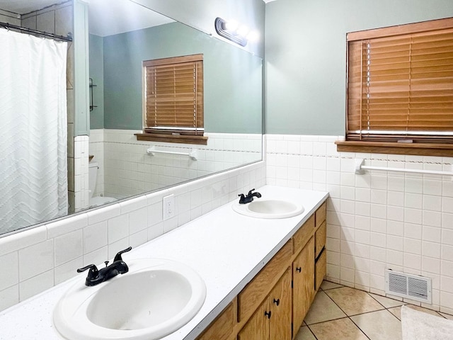 full bathroom featuring tile patterned floors, visible vents, double vanity, and a sink