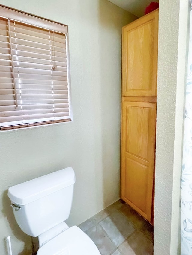 full bathroom featuring tile patterned floors and toilet