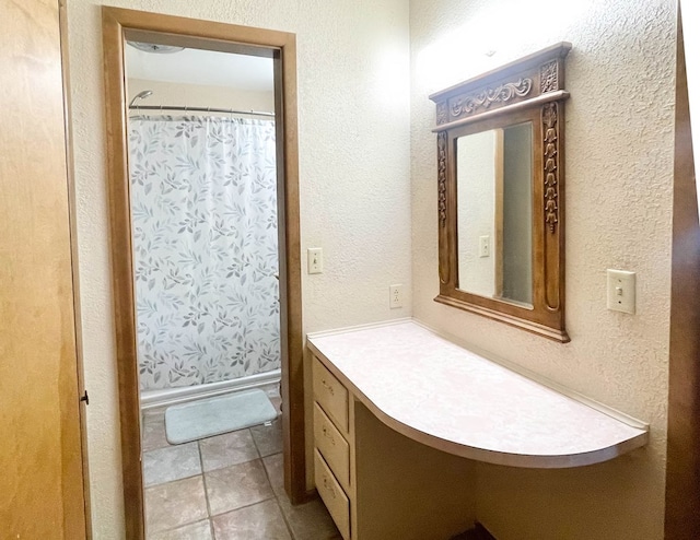 bathroom featuring tile patterned floors, a shower with curtain, vanity, and a textured wall