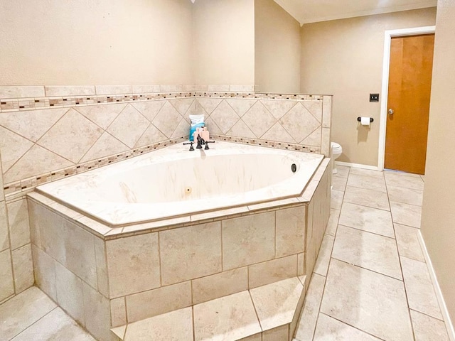 bathroom with baseboards, toilet, a bath, and tile patterned flooring