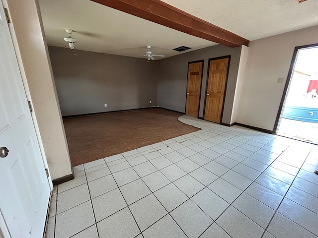 spare room with baseboards, a ceiling fan, light tile patterned flooring, and light carpet